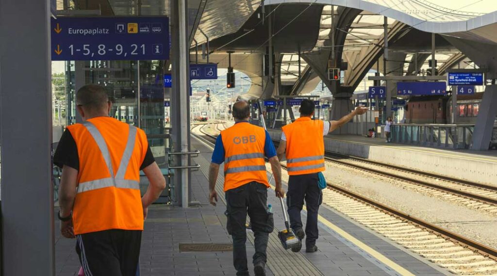 Arbeiter am Bahnhof mit Sicherheitswesten